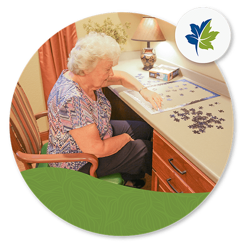 older woman doing a puzzle at a desk